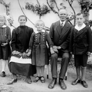 Zdjęcie rodzinne. Kobieta występuje w tradycyjnym śląskim stroju ludowym – w czarnej jakli (kaftanie), mazelonce (spódnicy ze stanikiem) i w zopasce (białym fartuchu). Oleszka (niem. Oleschka), około 1930 r.