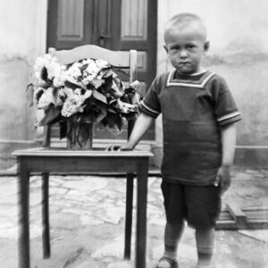 Chłopiec w wieku około trzech lat przed domem. Oleszka (niem. Oleschka), lata 30. XX w.