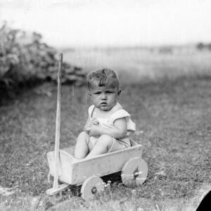 Około dwuletni chłopiec siedzący w drewnianym zabawkowym wózeczku. Oleszka (niem. Oleschka), lata 30. XX w.
